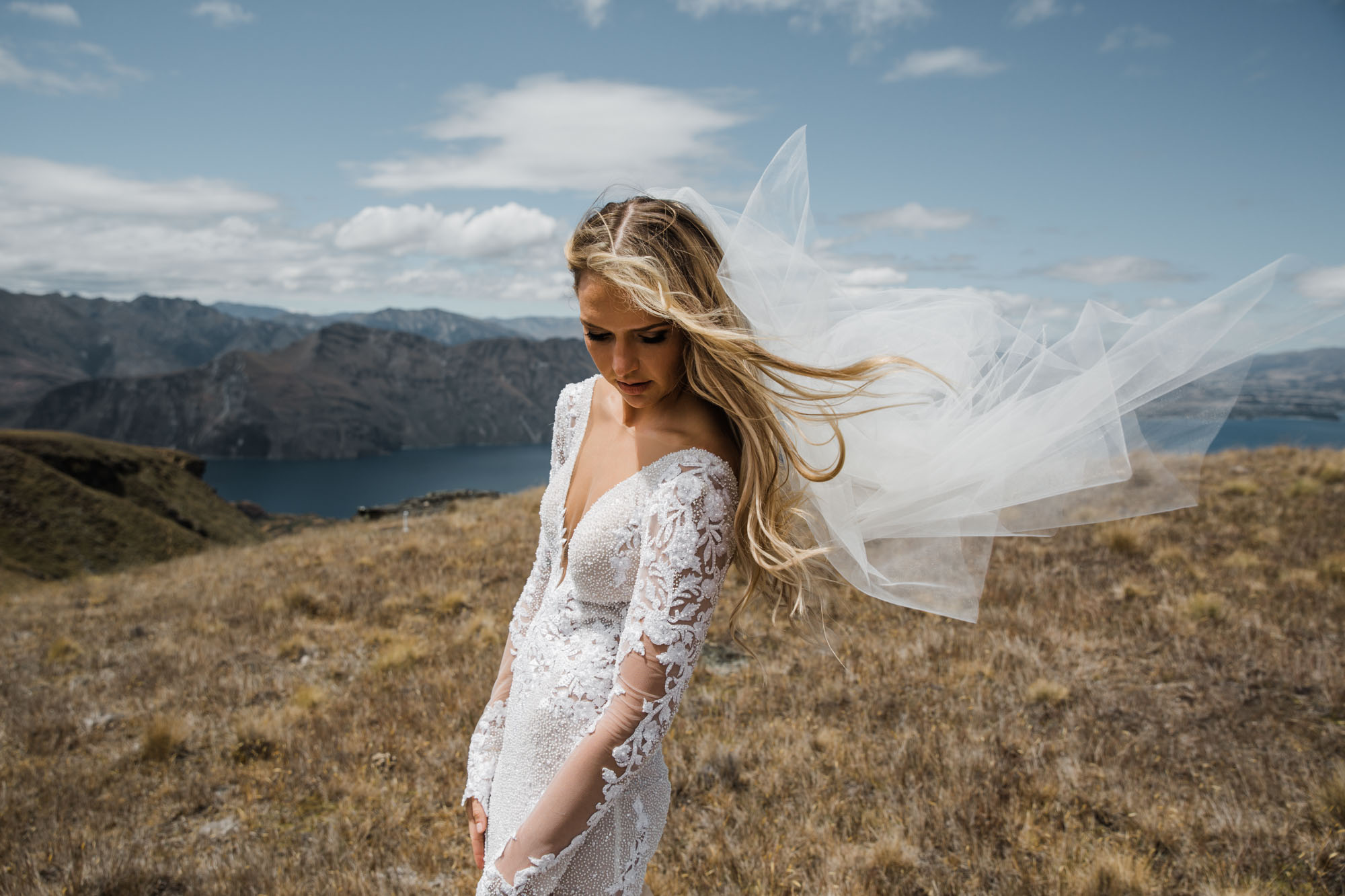 Bride with wind in her wil on top of a Queenstown mountain